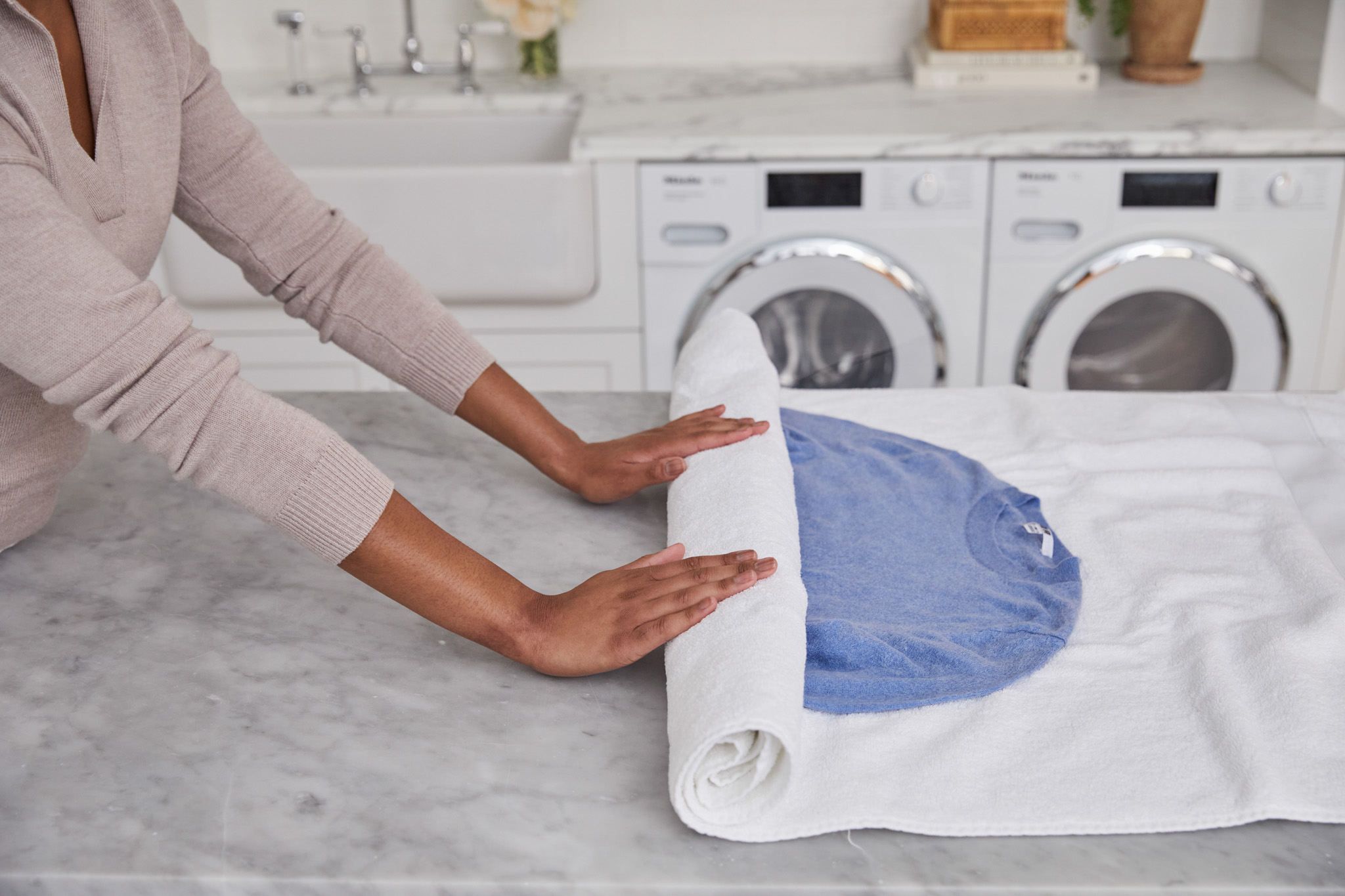 rolling up sweater in white towel after hand washing