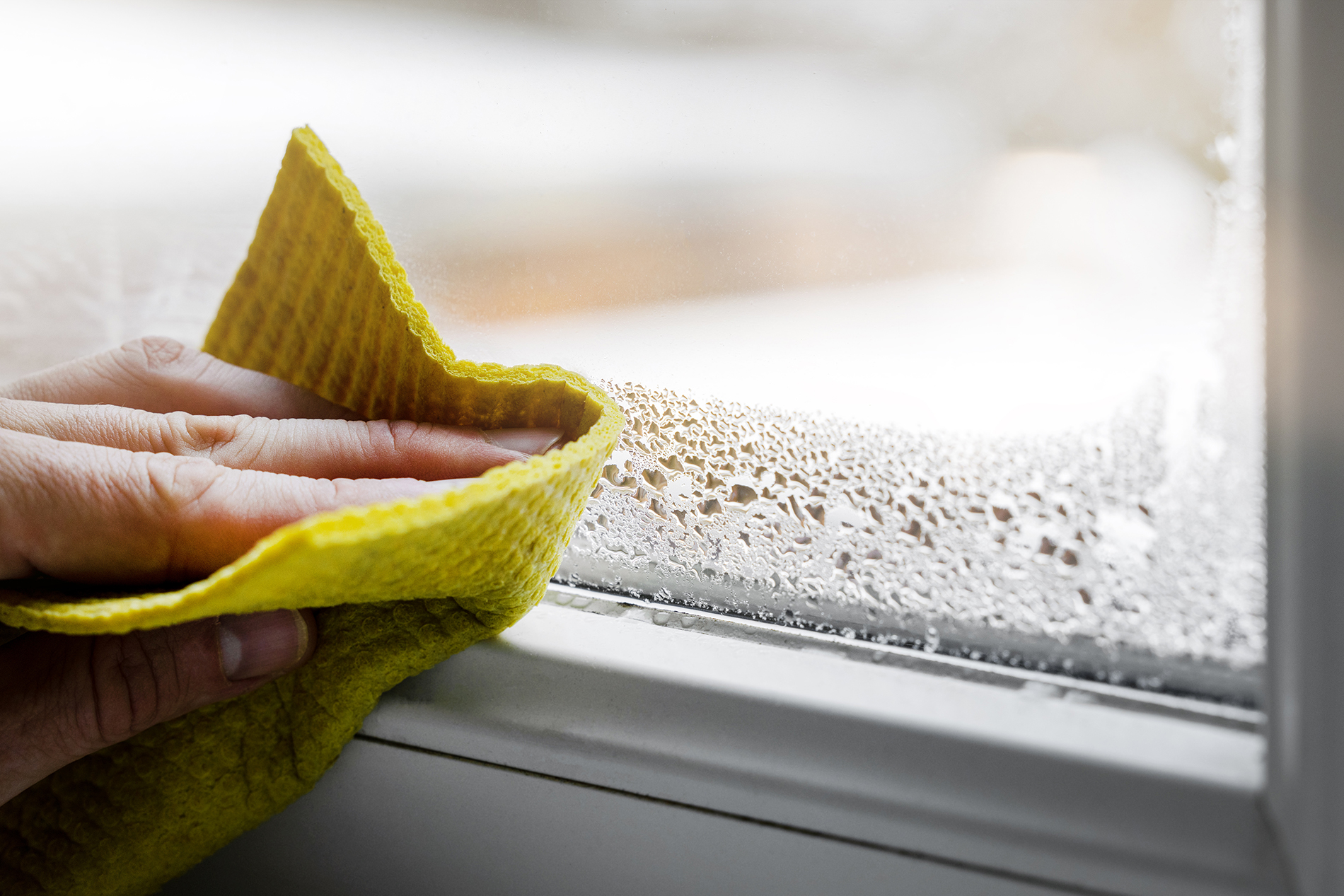 Wiping condensation from a window that needs better window winter insulation
